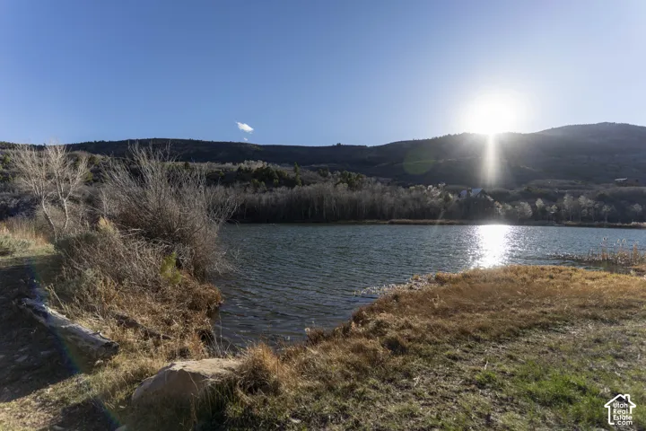 Lakefront property featuring a mountainous backdrop and natural shoreline
