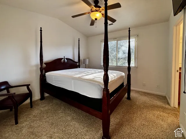 Vaulted ceiling with a ceiling fan, carpeted flooring, and window with horizontal blinds
