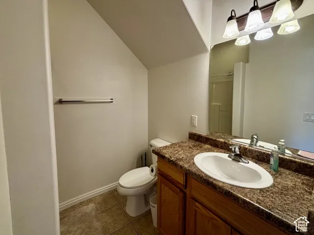 Bathroom vanity with an integrated sink, granite-look countertop, and wood-finish cabinetry