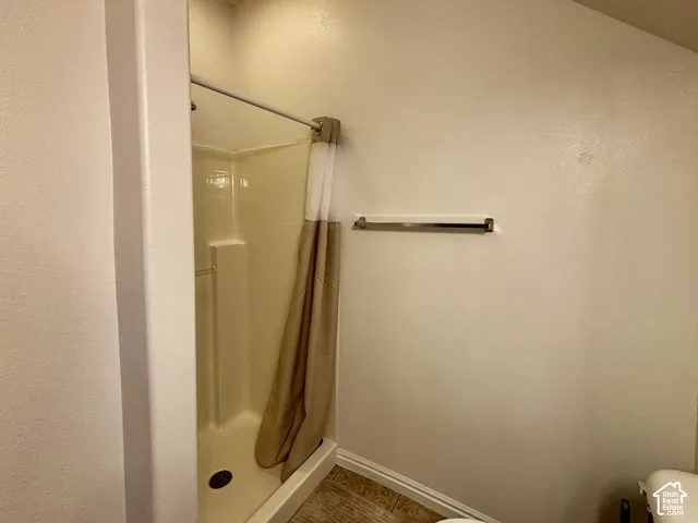 Walk-in shower with a chrome shower rod and a wall-mounted towel bar