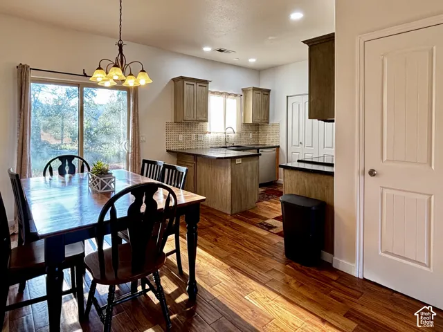 Kitchen and dining area featuring wood flooring, sliding glass door, recessed lighting, and a kitchen island with dark countertops