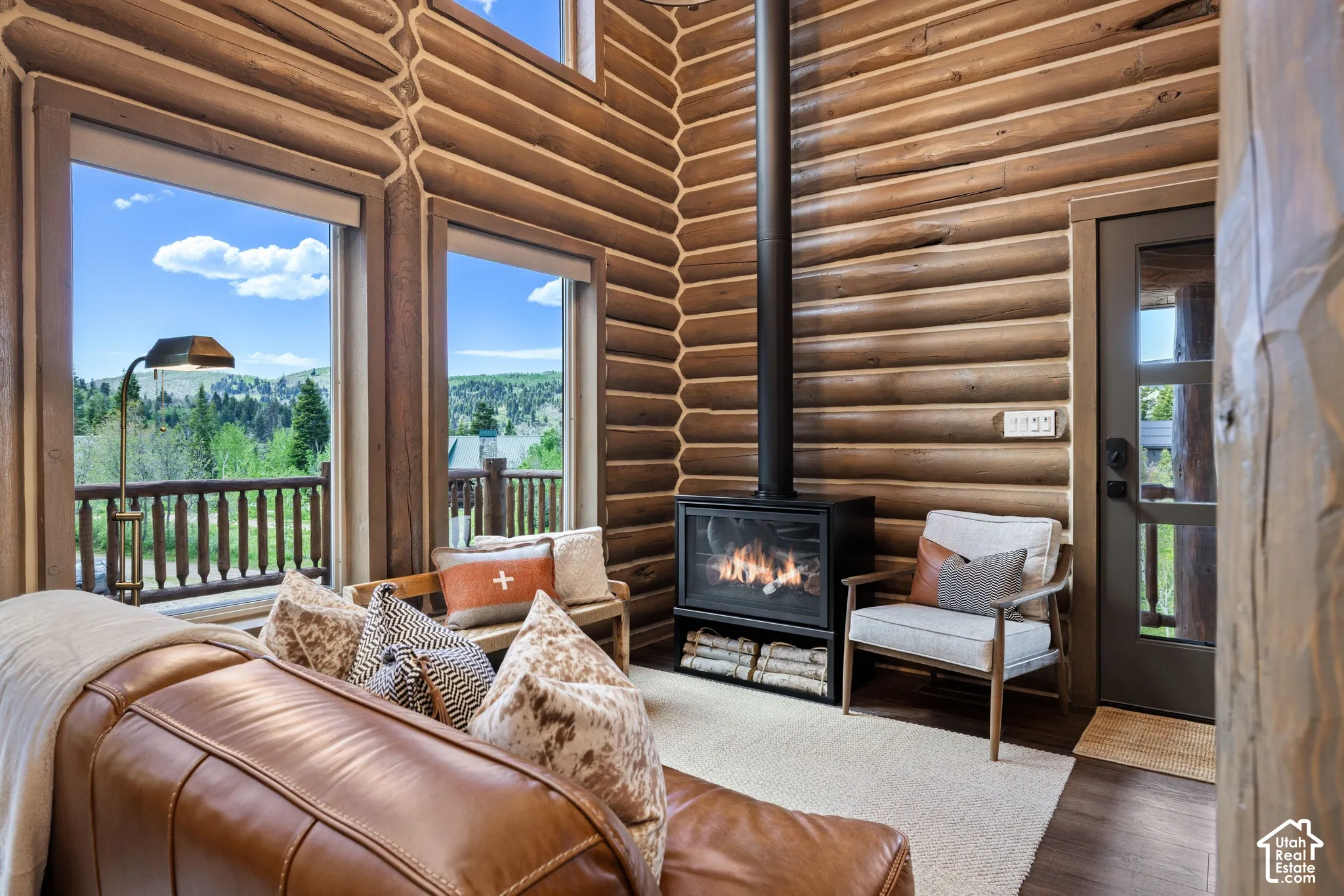 Wood-paneled interior walls, floor-to-ceiling windows, and a built-in fireplace with a hearth