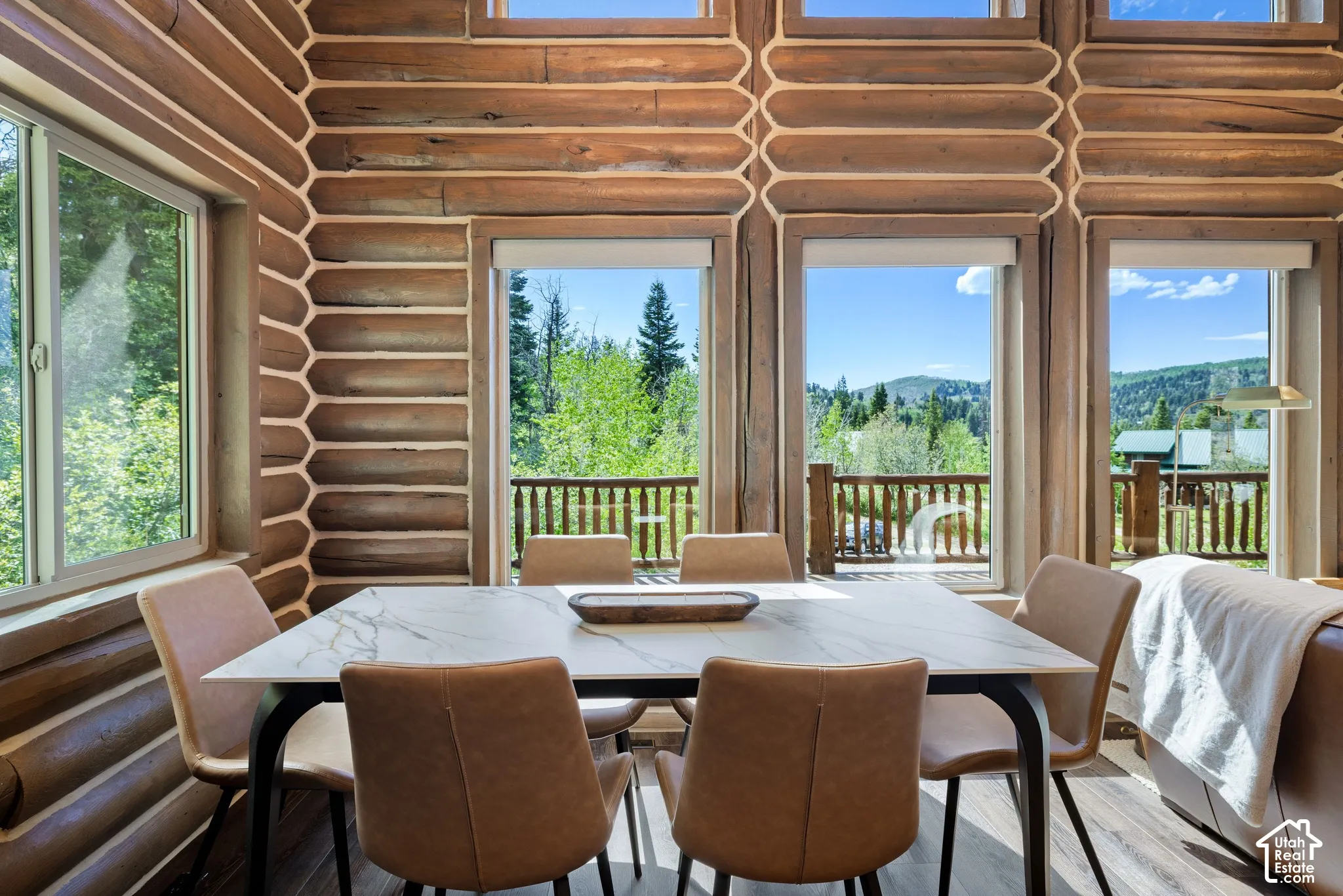 Log-style interior walls with chinking details, multiple windows, and a wood-finish flooring