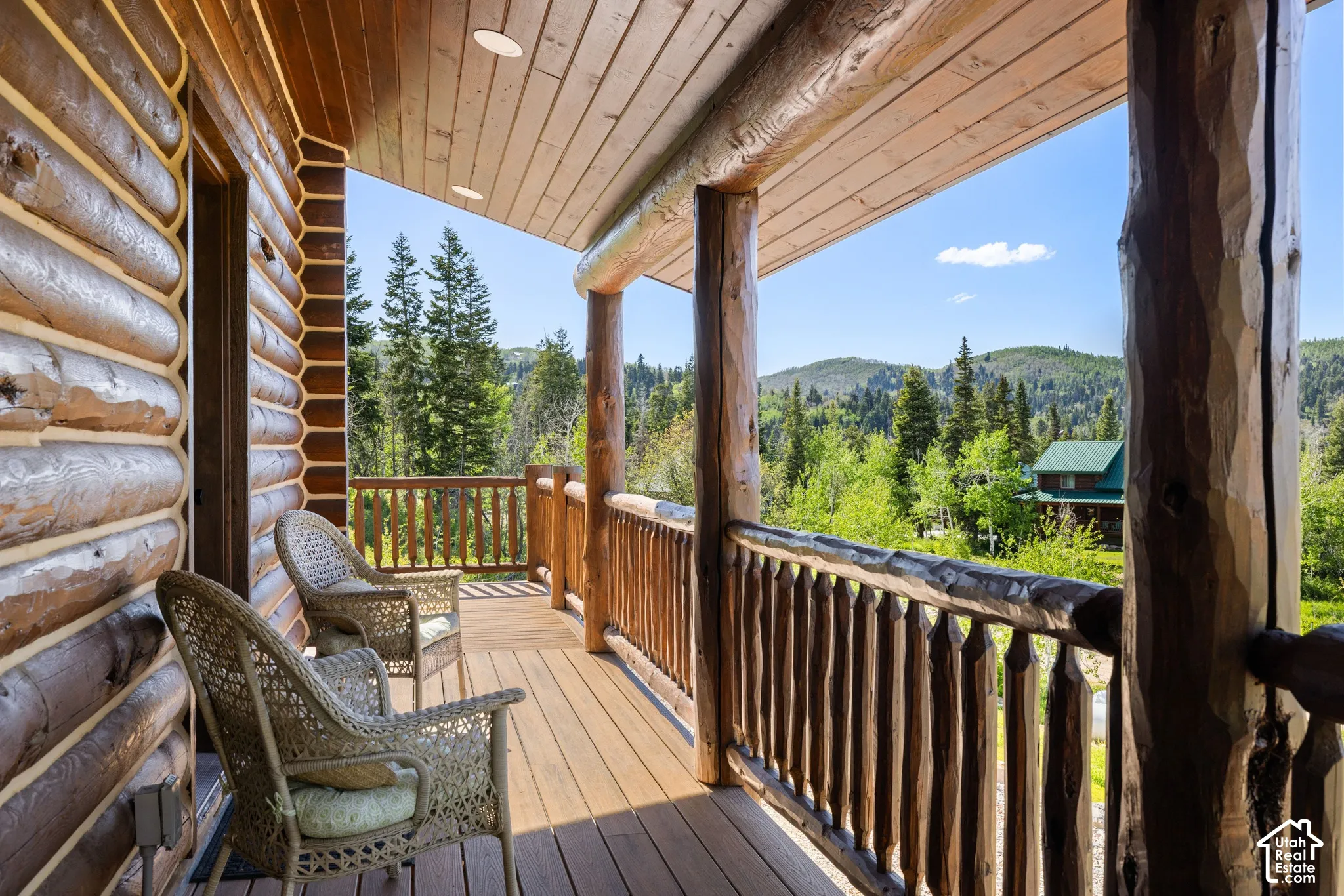 Expansive deck featuring wood-finish decking, log-style railings, and a wood-paneled ceiling