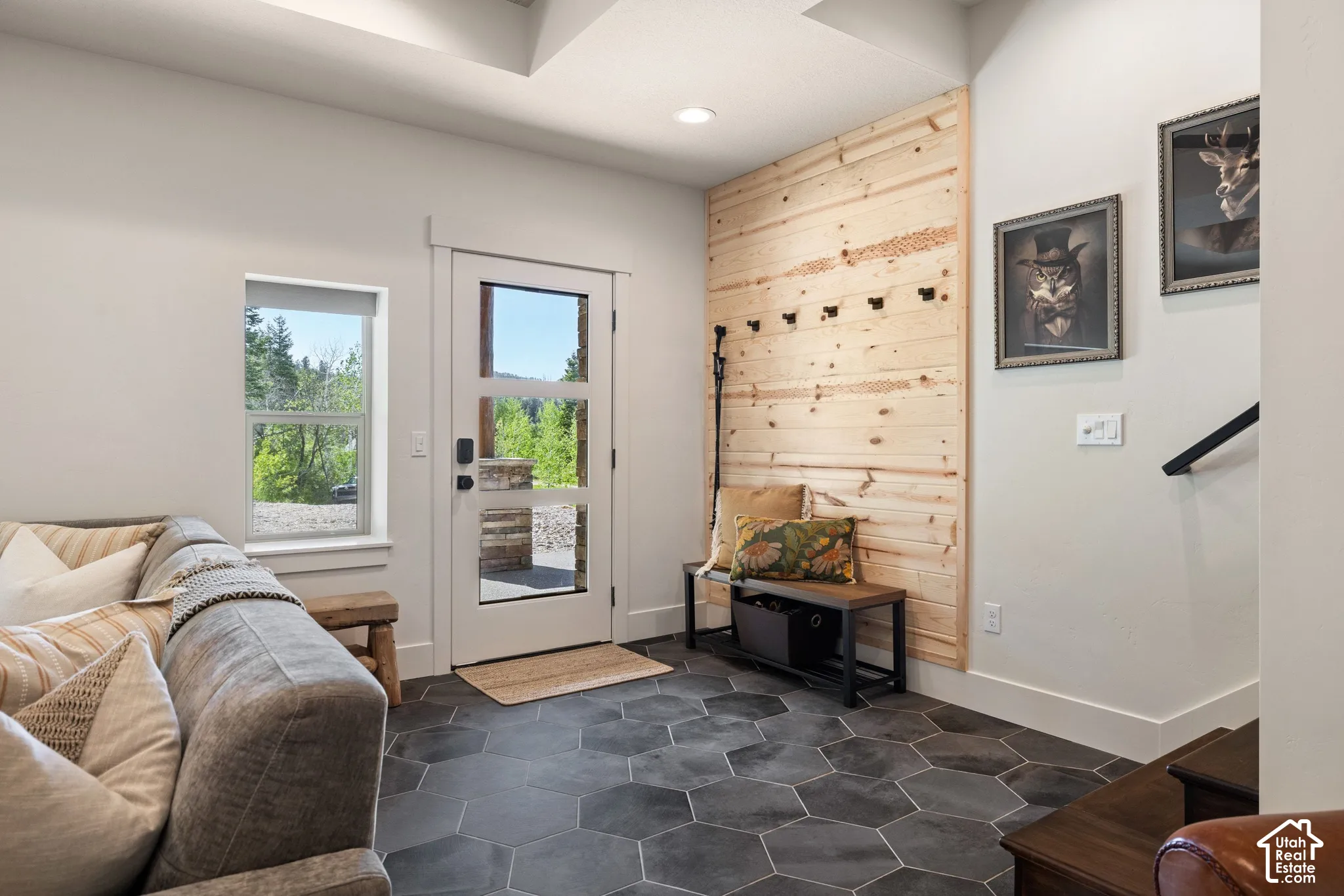 Entryway featuring hexagonal floor tiles, a full-lite entry door, a shiplap accent wall with integrated hooks, and a built-in storage bench