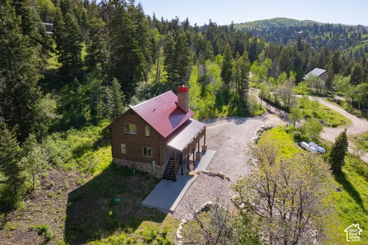 Log-sided residence with a red metal roof and stone foundation