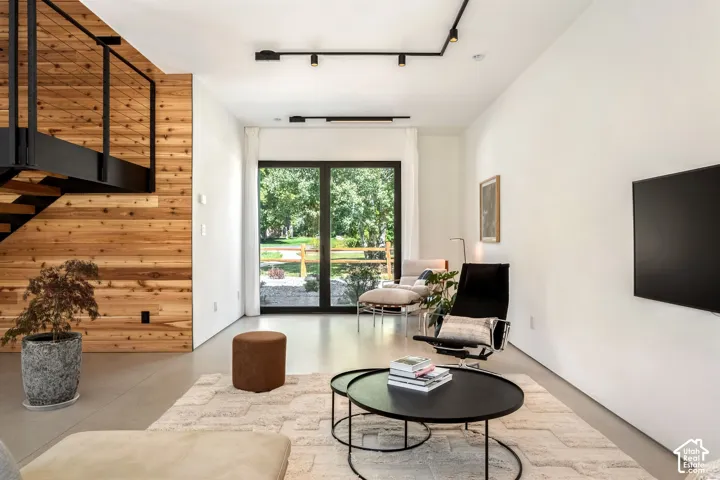 Wood-paneled wall with open-tread staircase and black metal railing