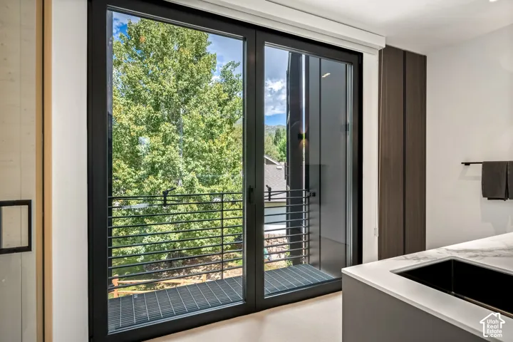 Sliding glass door leading to an exterior balcony with a black metal railing