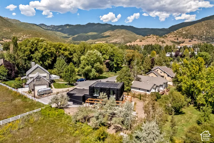 Modern black exterior with expansive surrounding greenery and mountain backdrop