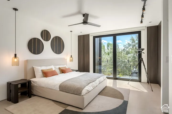 Full-height glass sliding doors, dark wood-finish wall panels, a ceiling fan, and track lighting