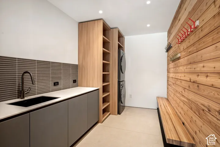 Integrated laundry appliances, built-in shelving, wood-paneled wall, built-in wooden bench, and recessed ceiling lighting