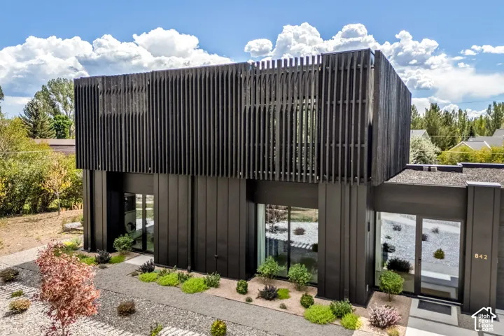 Modern architectural design with dark vertical siding and slatted upper exterior