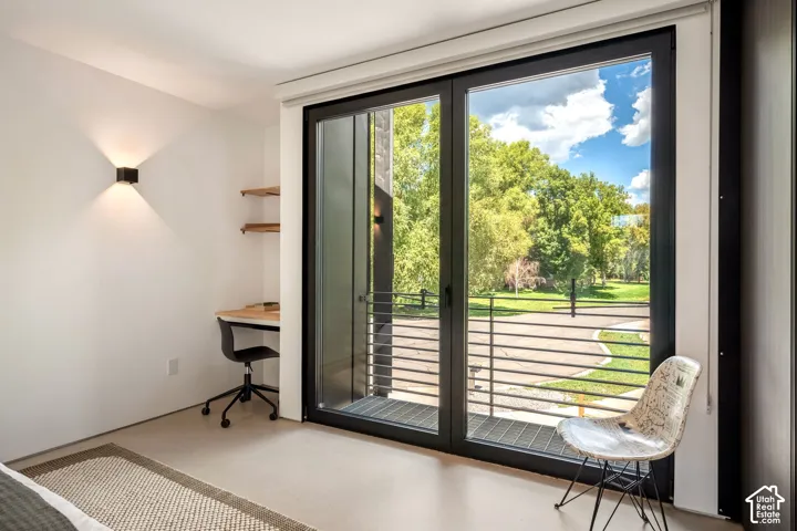 Expansive glass sliding door, metal balcony railing, and modern wall-mounted lighting