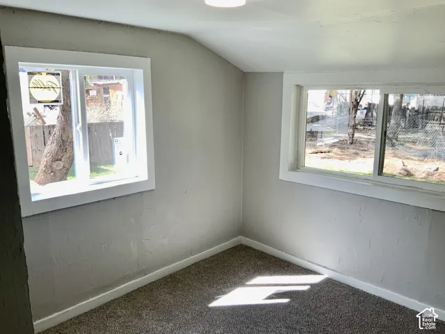 Neutral-toned walls, two distinct windows, white trim, and light-colored carpeting