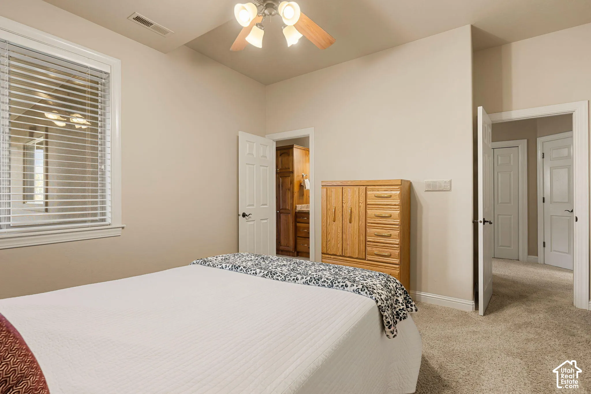 Ceiling fan fixture, white trim window, light neutral wall paint, white interior doors, and carpeted flooring
