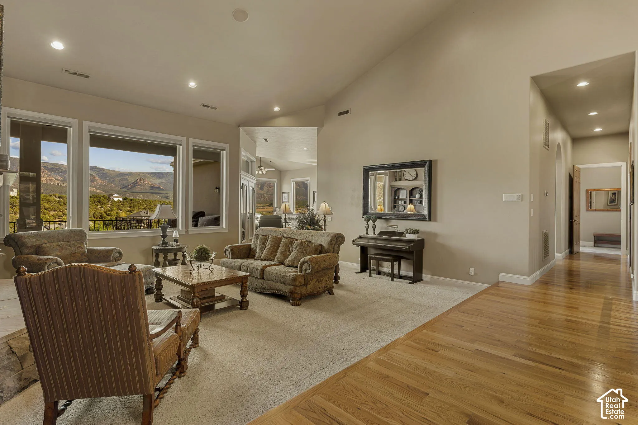 Recessed lighting, wood-finish flooring, vaulted ceilings, and large windows with mountain scenery