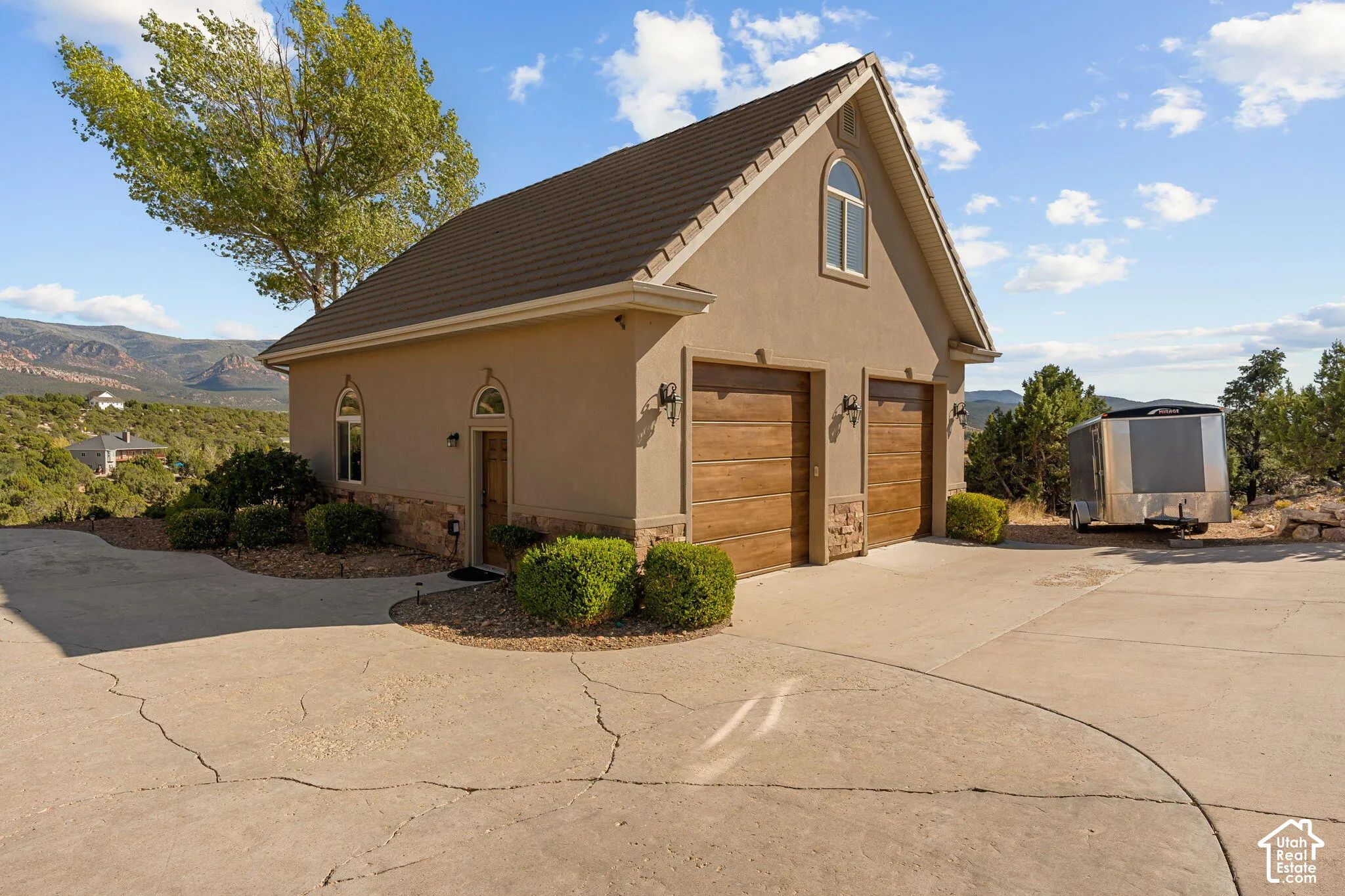 Two-car garage with wood-finish doors and exterior lighting fixtures