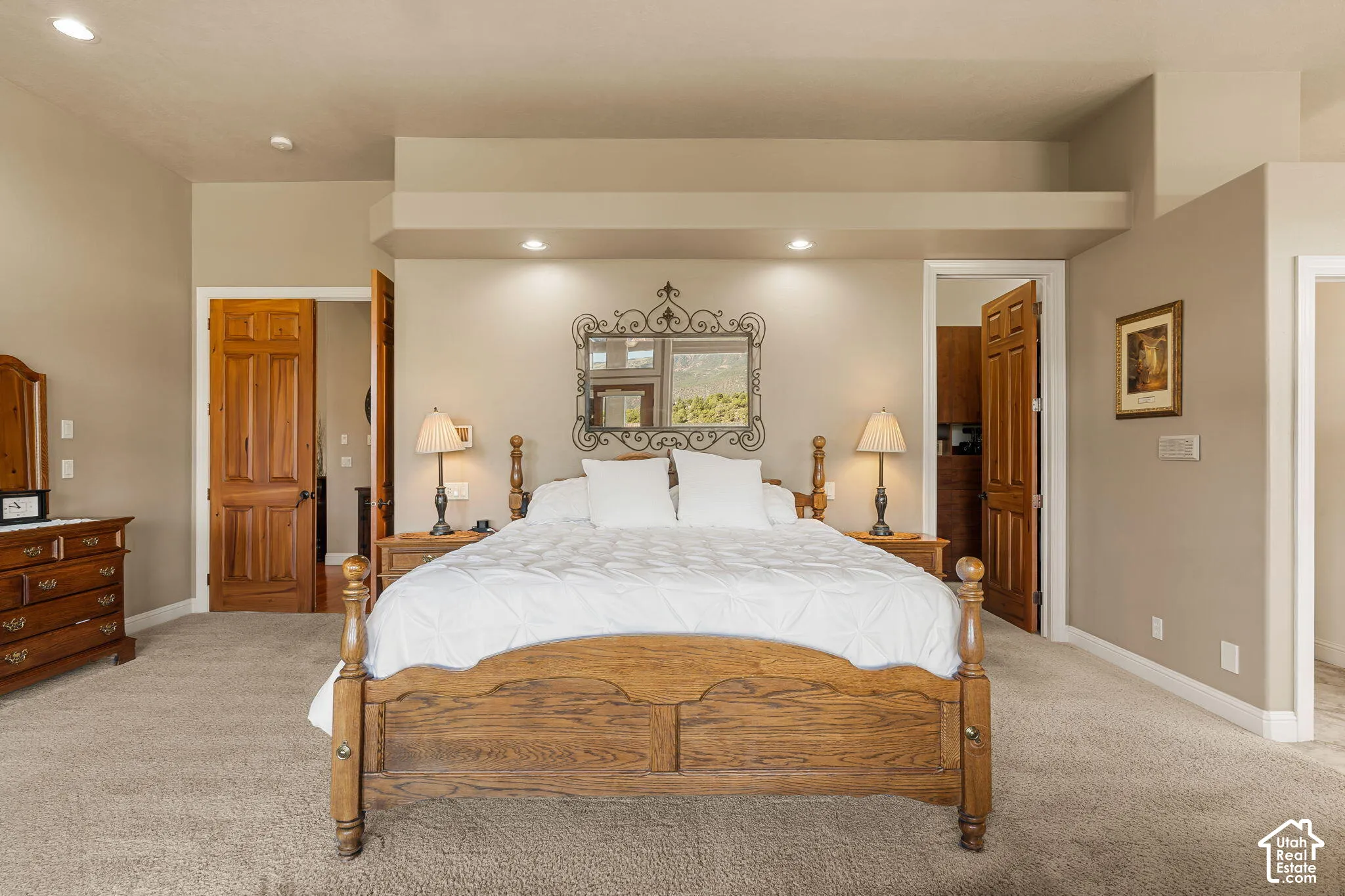Recessed lighting illuminates the neutral-toned walls and carpeted flooring