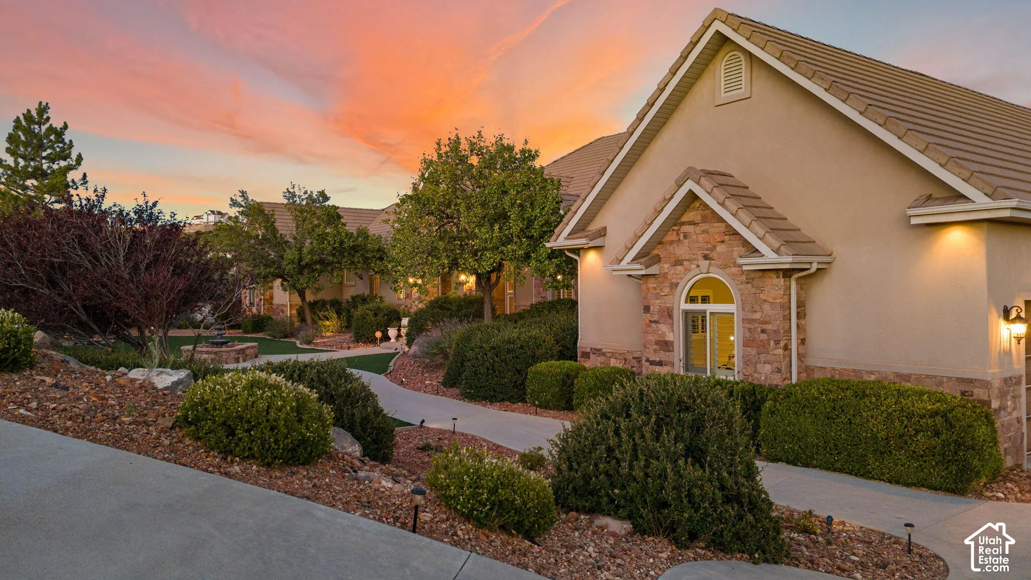 Stucco exterior with stone accents, arched window, and tiled roofing