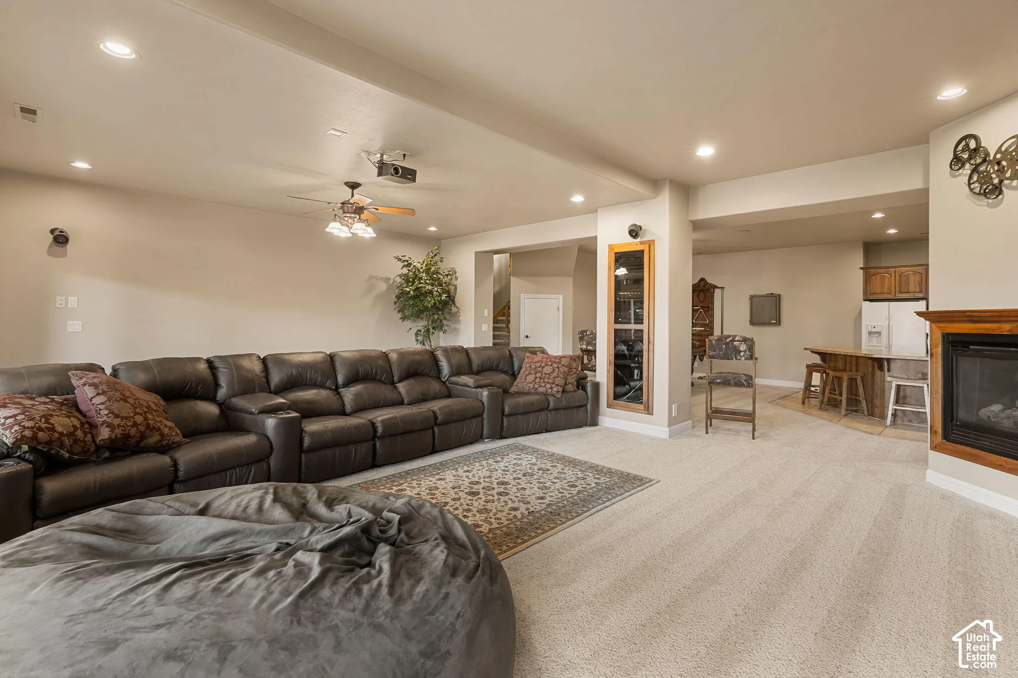 Recessed lighting, ceiling fan, built-in fireplace with wood mantel, built-in bar with wood cabinetry, and carpeted flooring