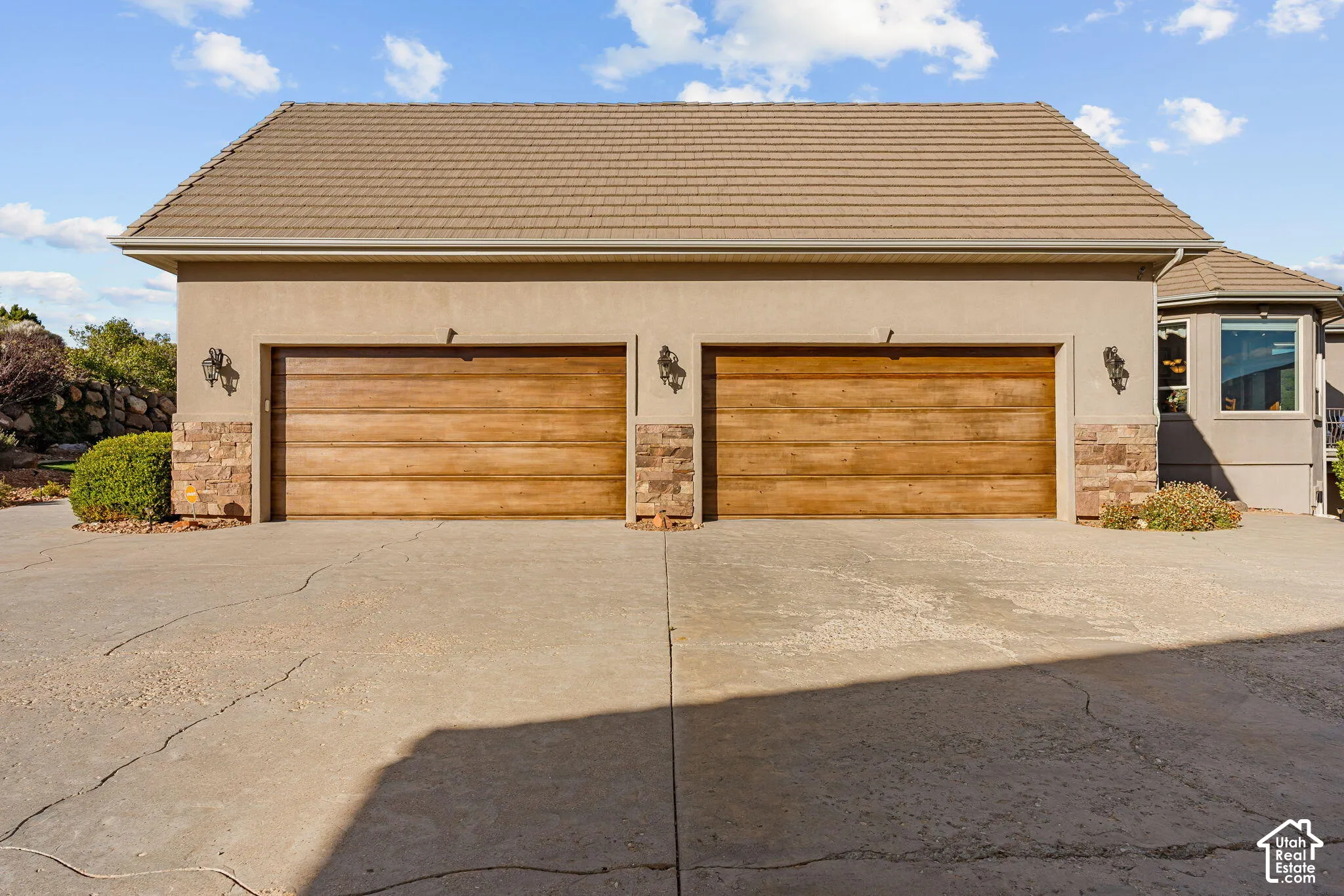 Two wood-finish garage doors with decorative wall sconces