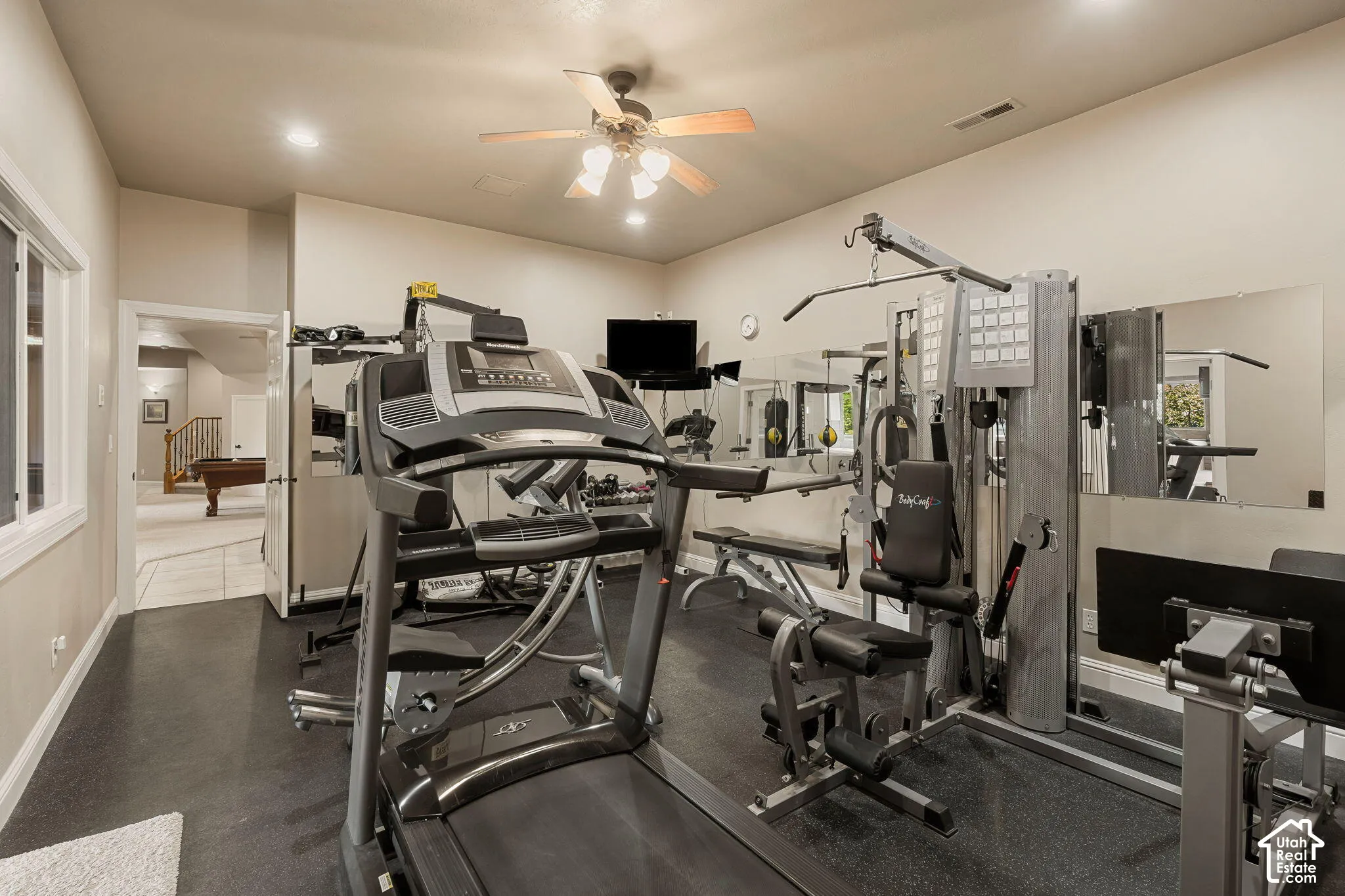 Dedicated exercise space featuring rubber flooring and mirrored wall