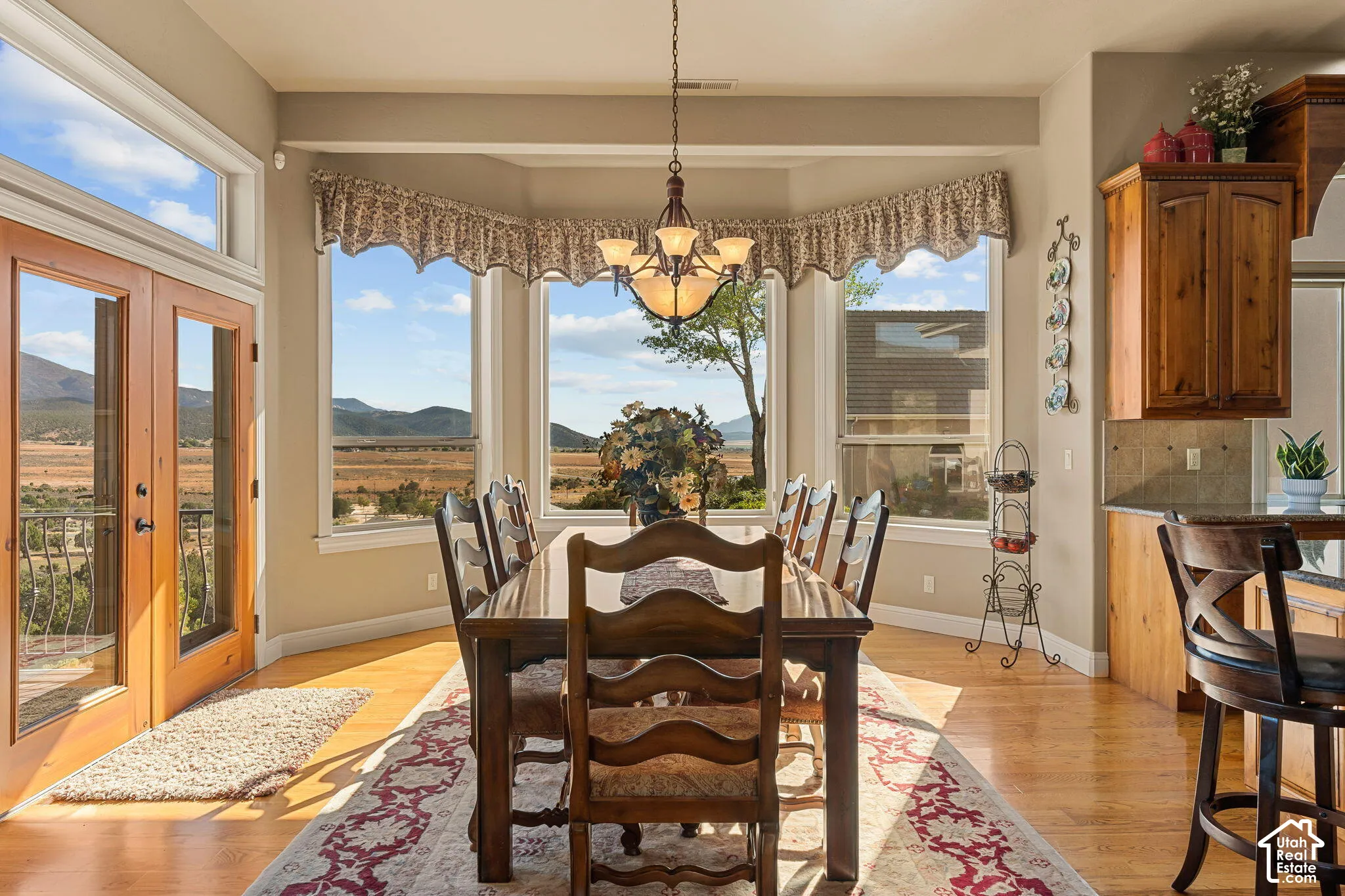 Bay window dining area with hardwood flooring, a multi-pane glass door, and a built-in kitchen peninsula with wood cabinetry