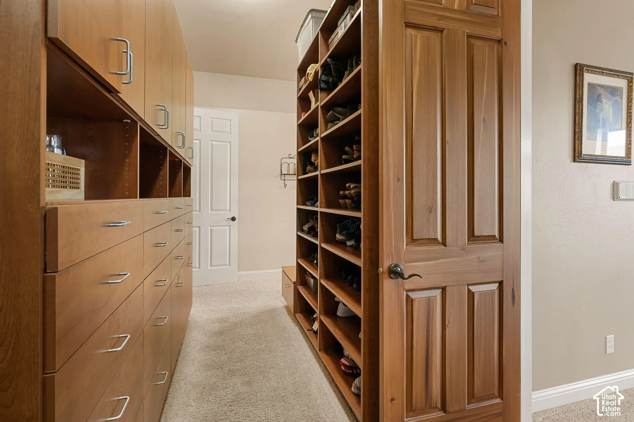 Built-in closet system featuring wood-finish cabinetry, integrated shelving, and multiple storage drawers with polished hardware