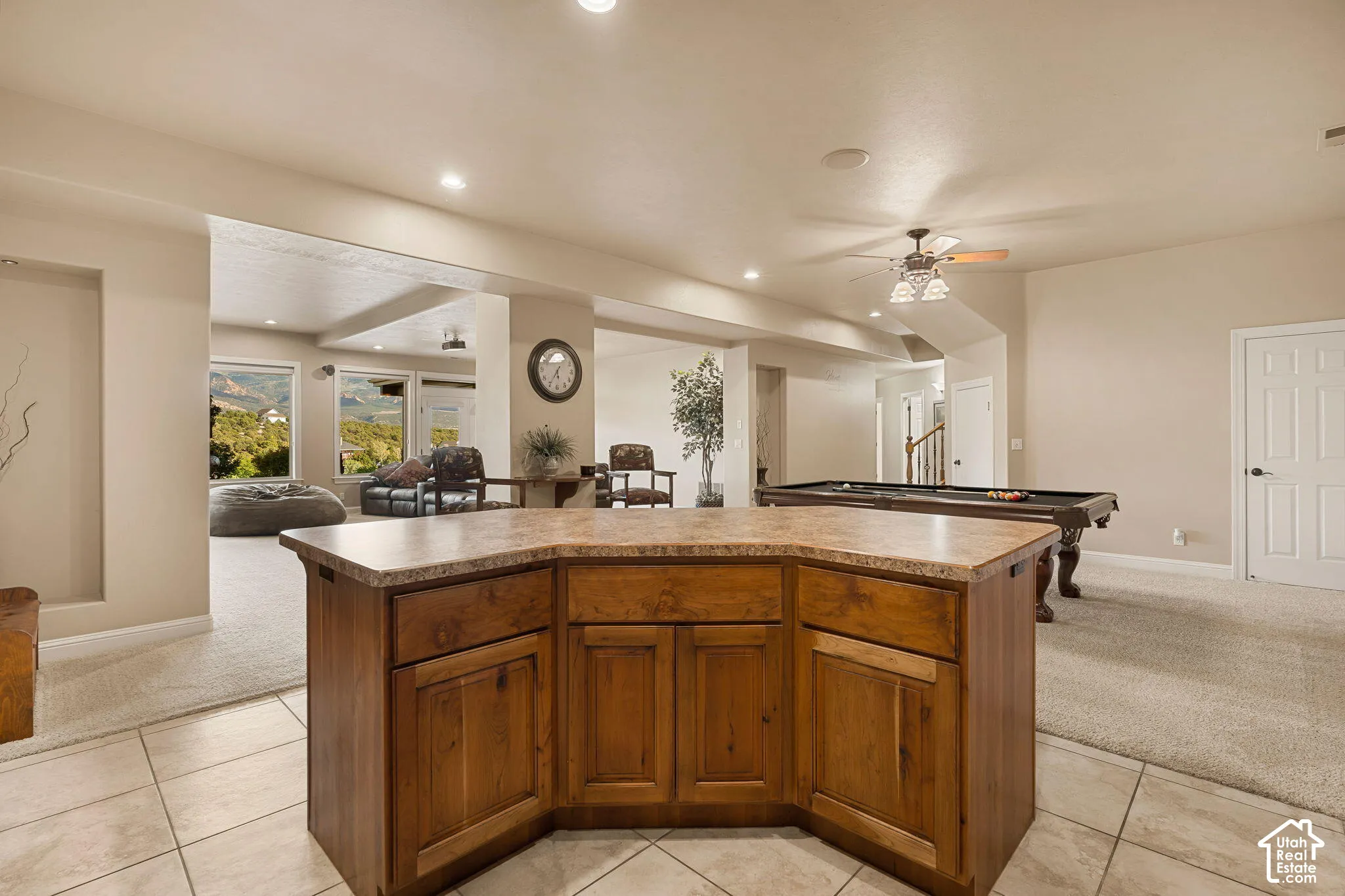 Open-concept living space featuring a wood-finish island with a stone-finish countertop, recessed lighting, and a ceiling fan