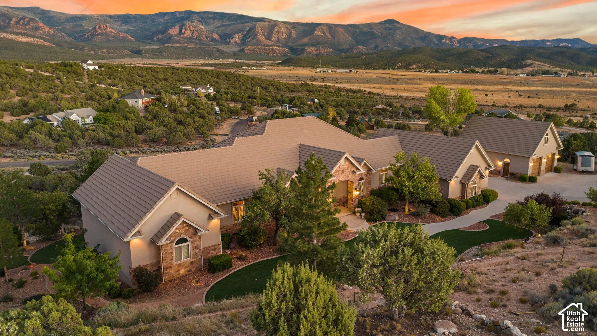 Stucco exterior with stone accents, covered entry, and pitched tile roofing