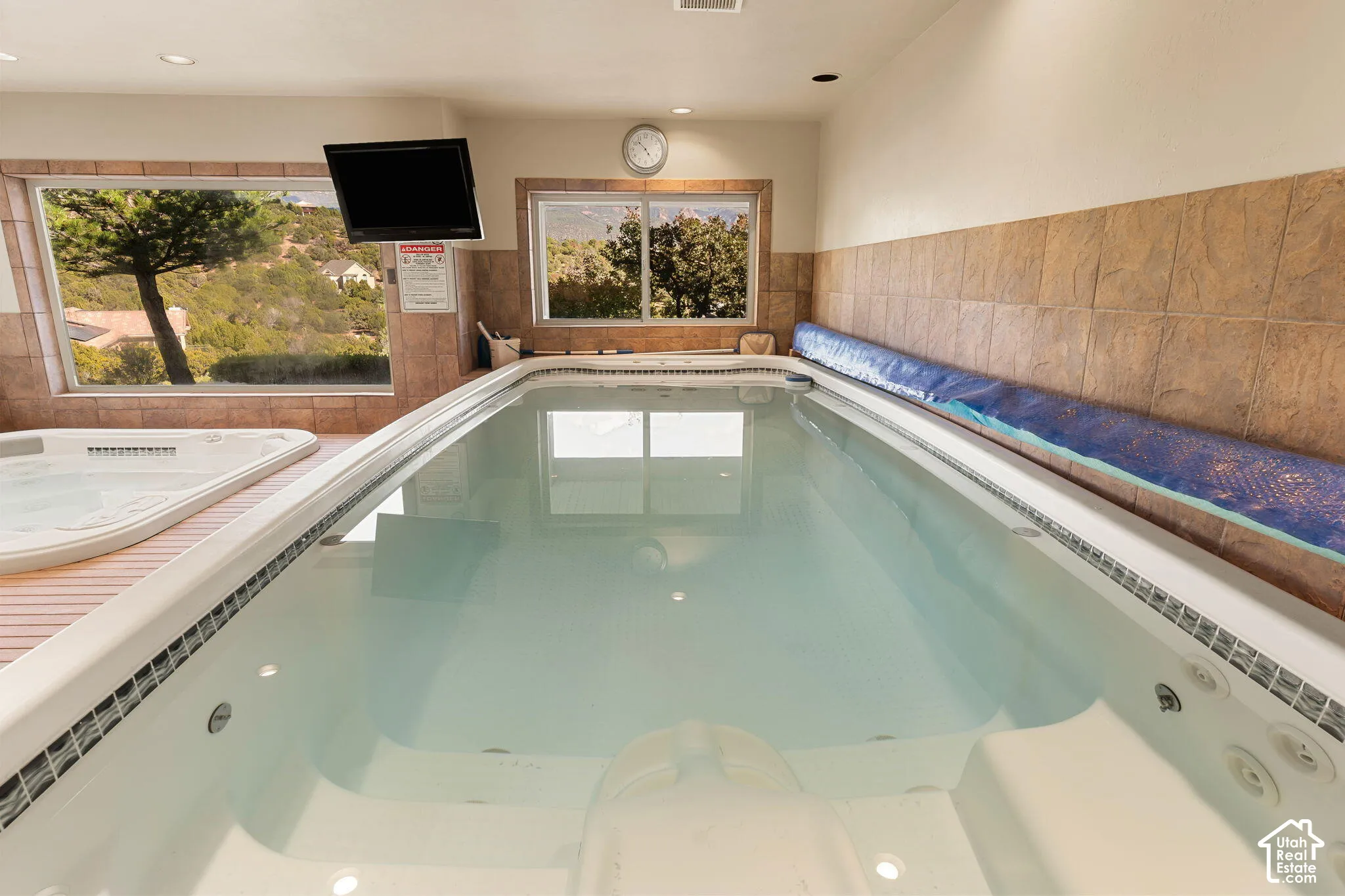 Indoor lap pool with integrated spa and tiled surround