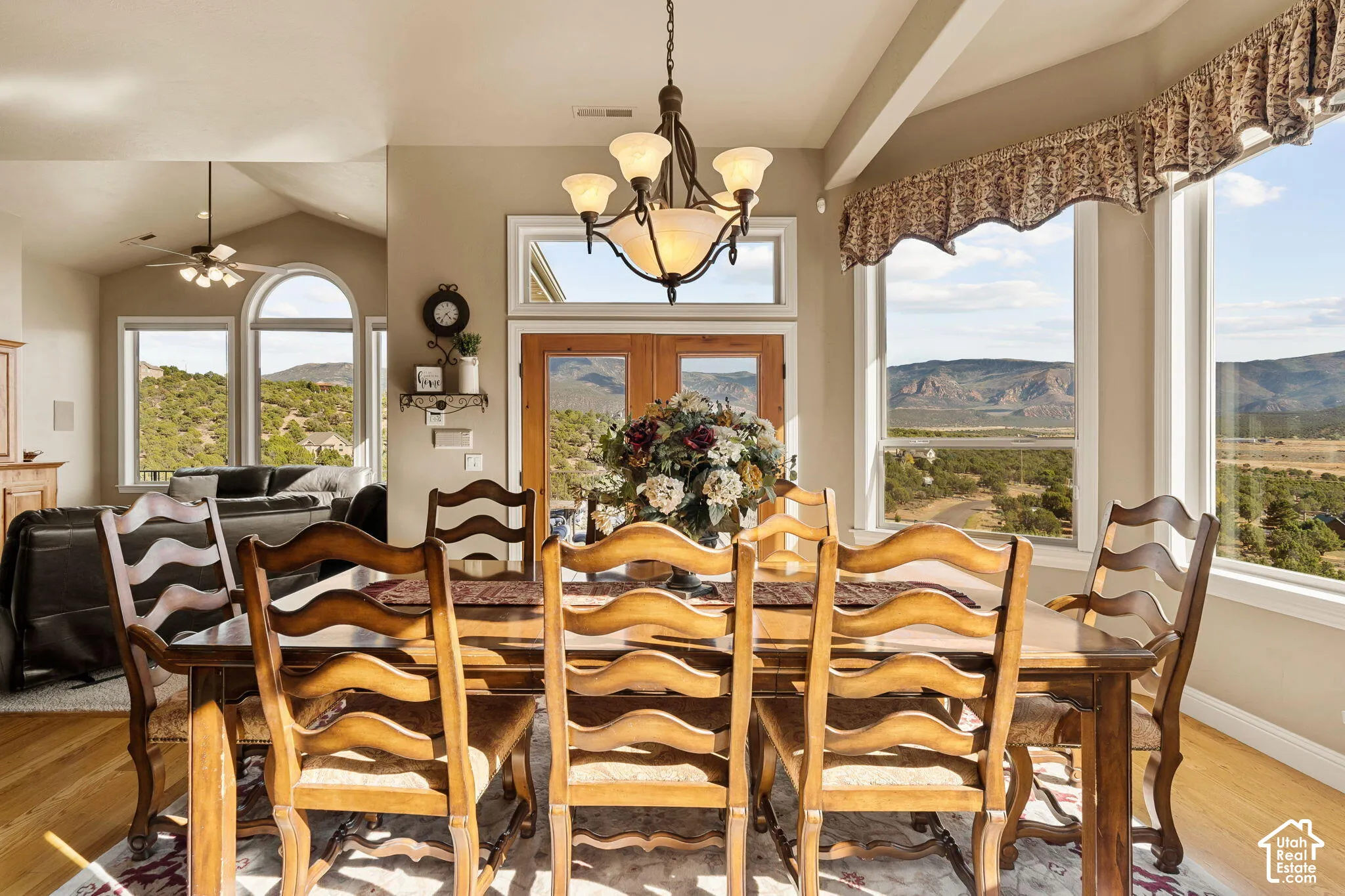 Wood-finish flooring, vaulted ceilings, and large windows with transom detailing