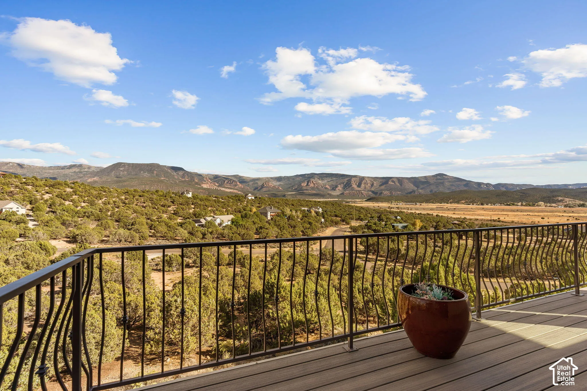 Exterior deck with a metal railing and expansive mountain and valley scenery