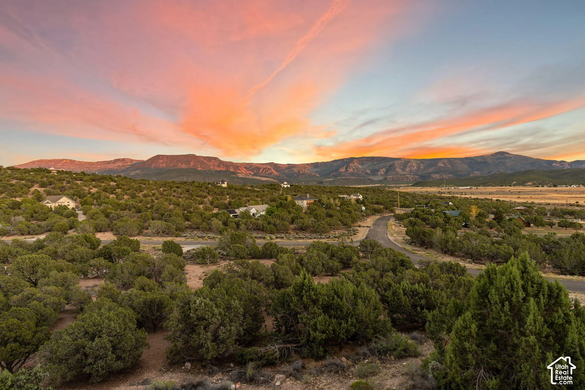 Mountain backdrop with scattered homes and a paved road