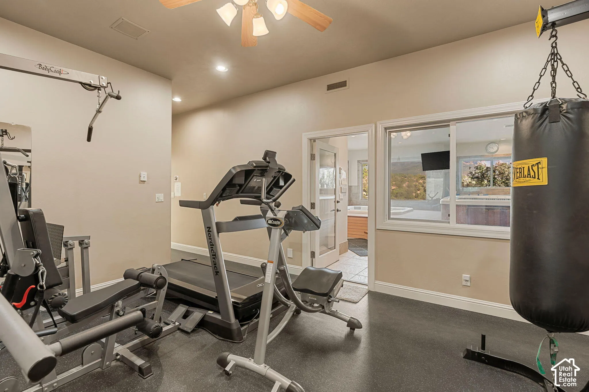 Dedicated exercise room featuring recessed lighting, a ceiling fan, and rubberized flooring