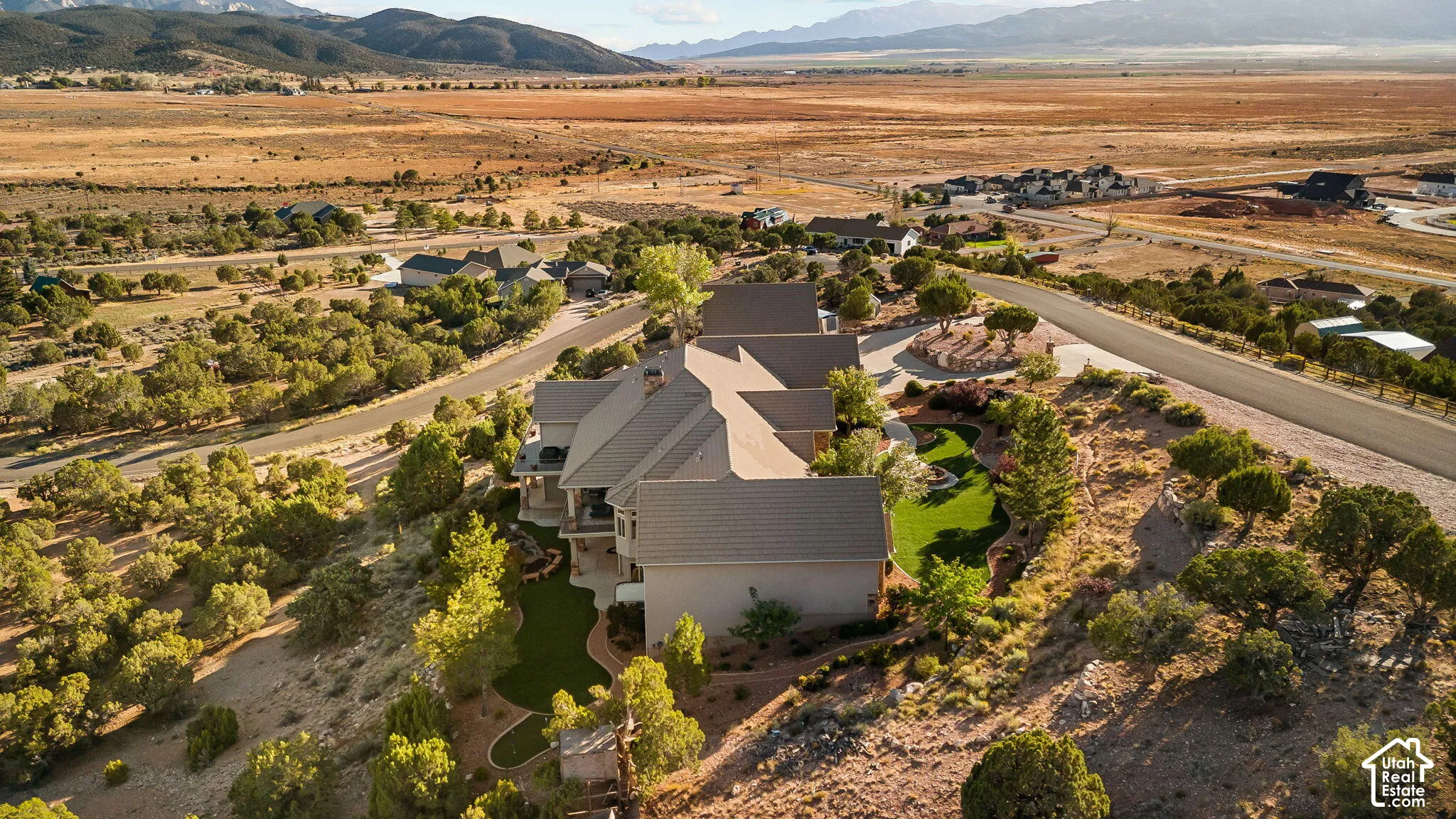 Expansive property featuring a multi-level structure with a gabled roof, terraced landscaping, and a manicured green space