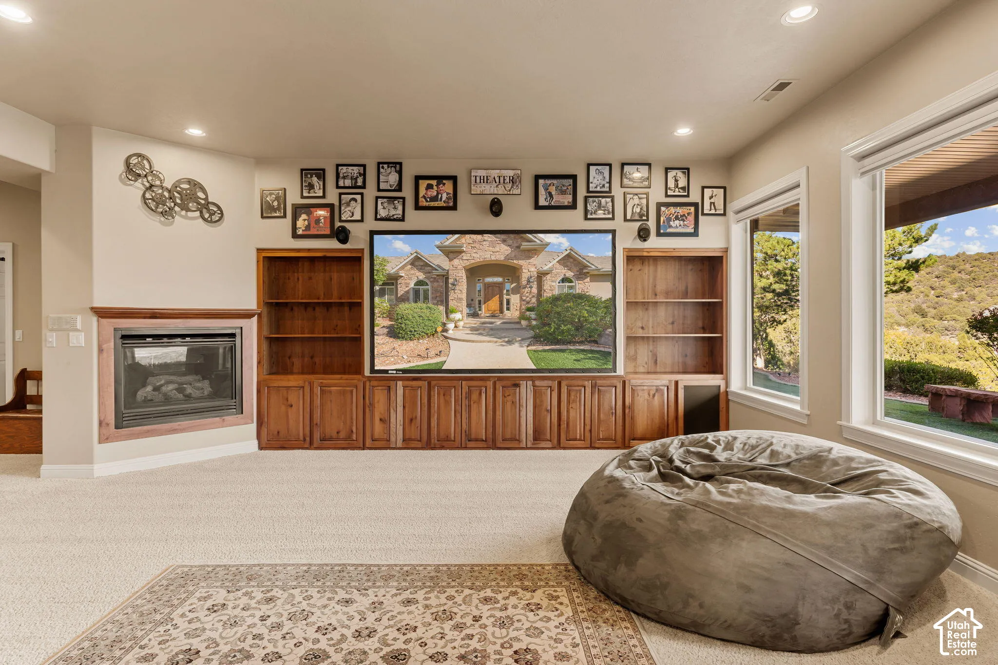 Built-in media center with wood cabinetry and shelving, recessed lighting, and a corner fireplace with a wood surround