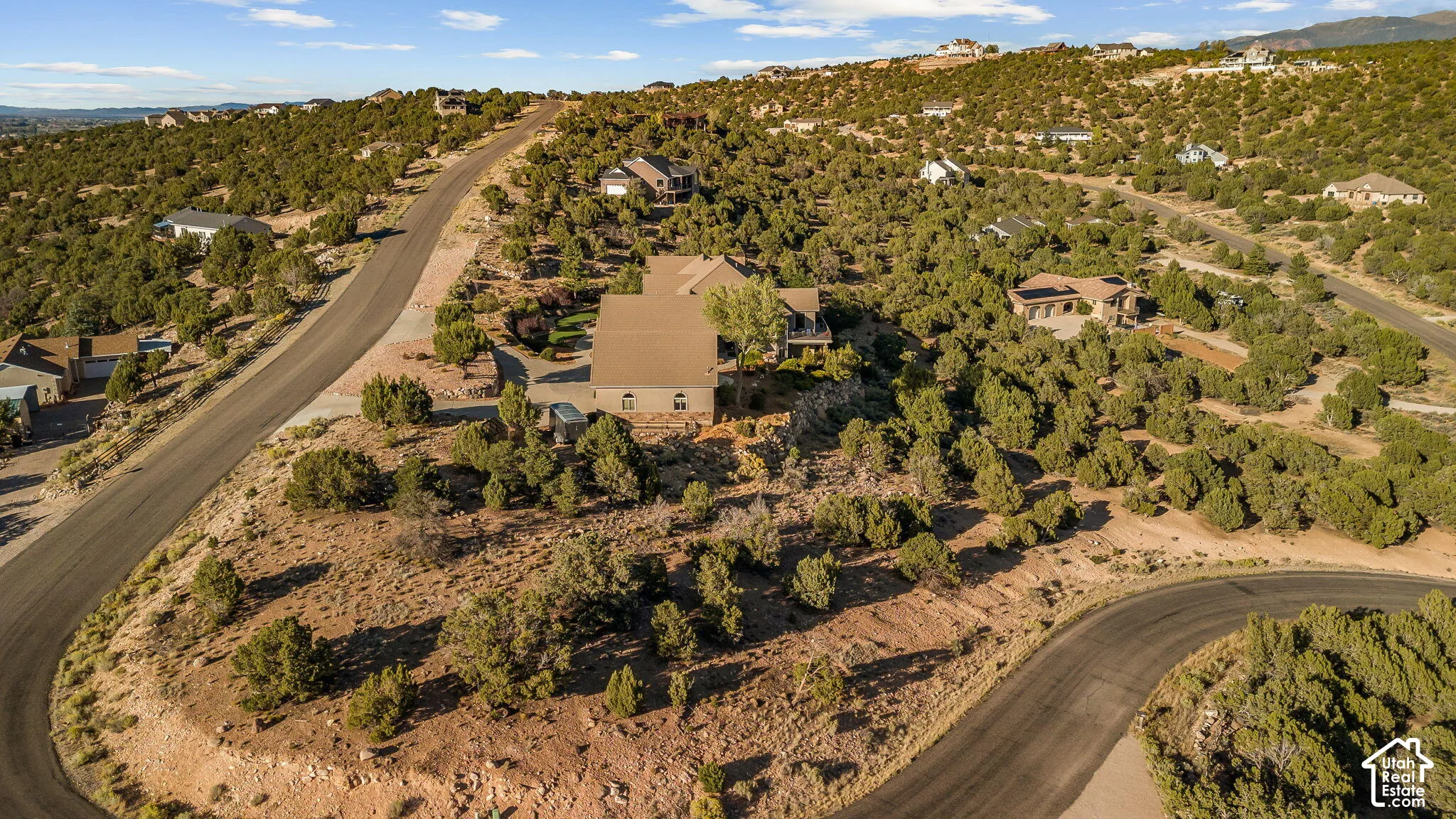 Extensive property situated on a winding paved road, surrounded by natural desert landscaping and scattered residences
