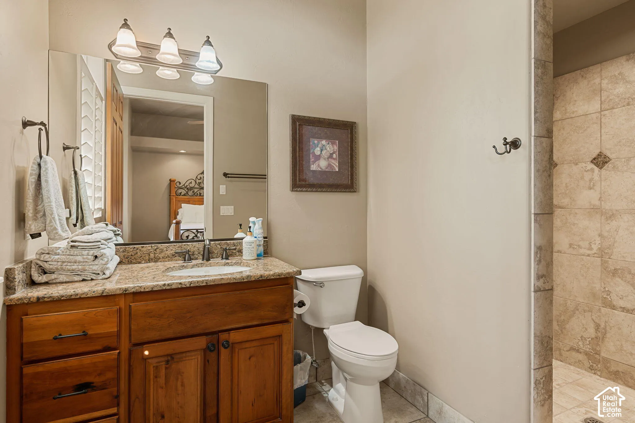 Vanity with stone countertop, integrated sink, and wood cabinetry