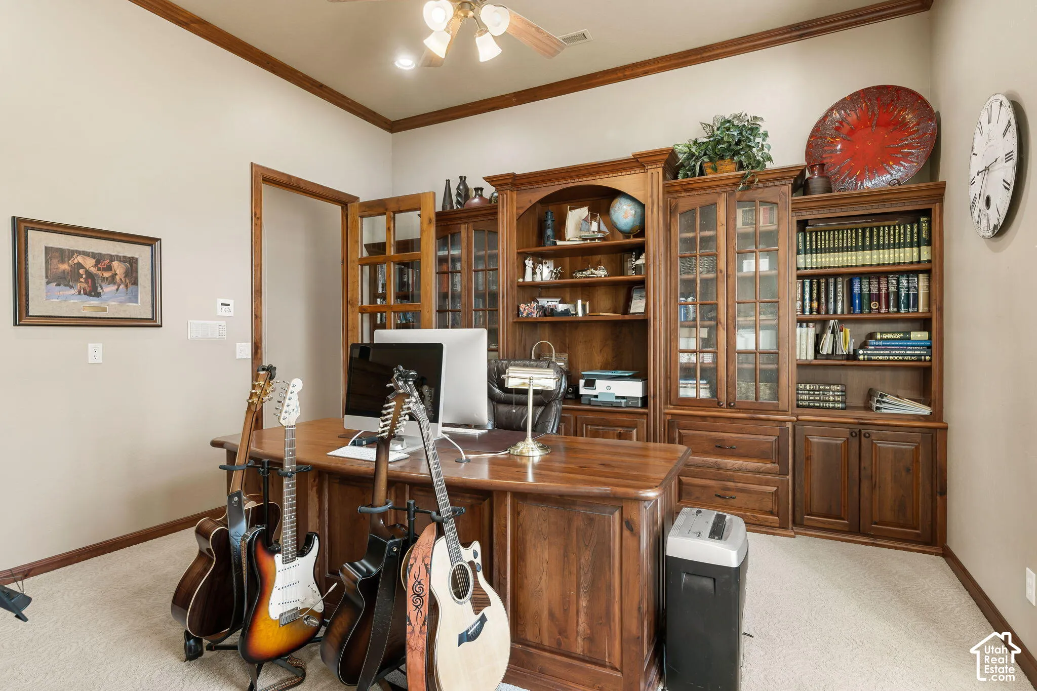 Built-in wood cabinetry with glass door accents, wood-finish desk, and wood trim