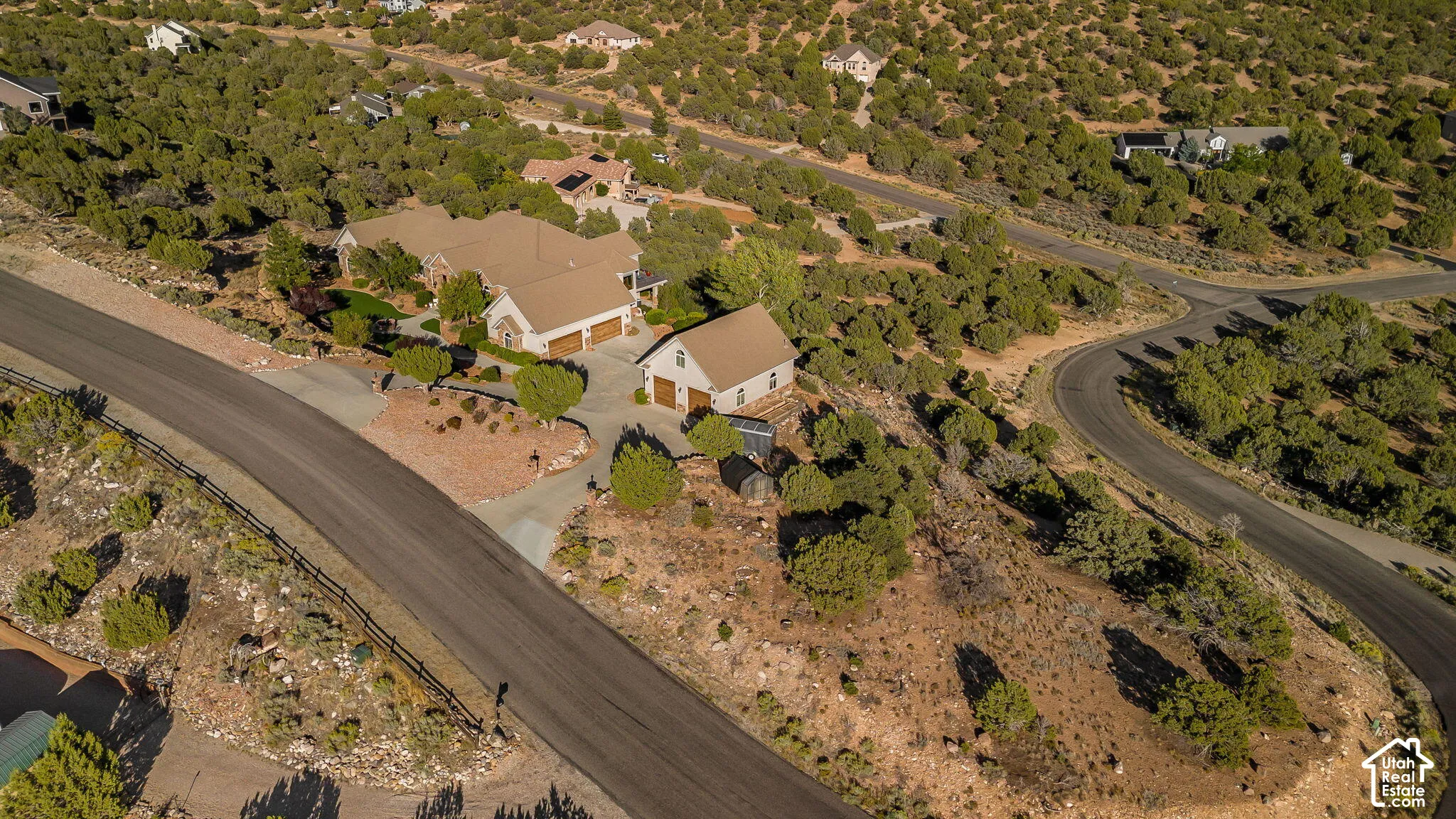 Property featuring a main residence with a two-car garage, an additional detached two-car garage structure, and paved driveways