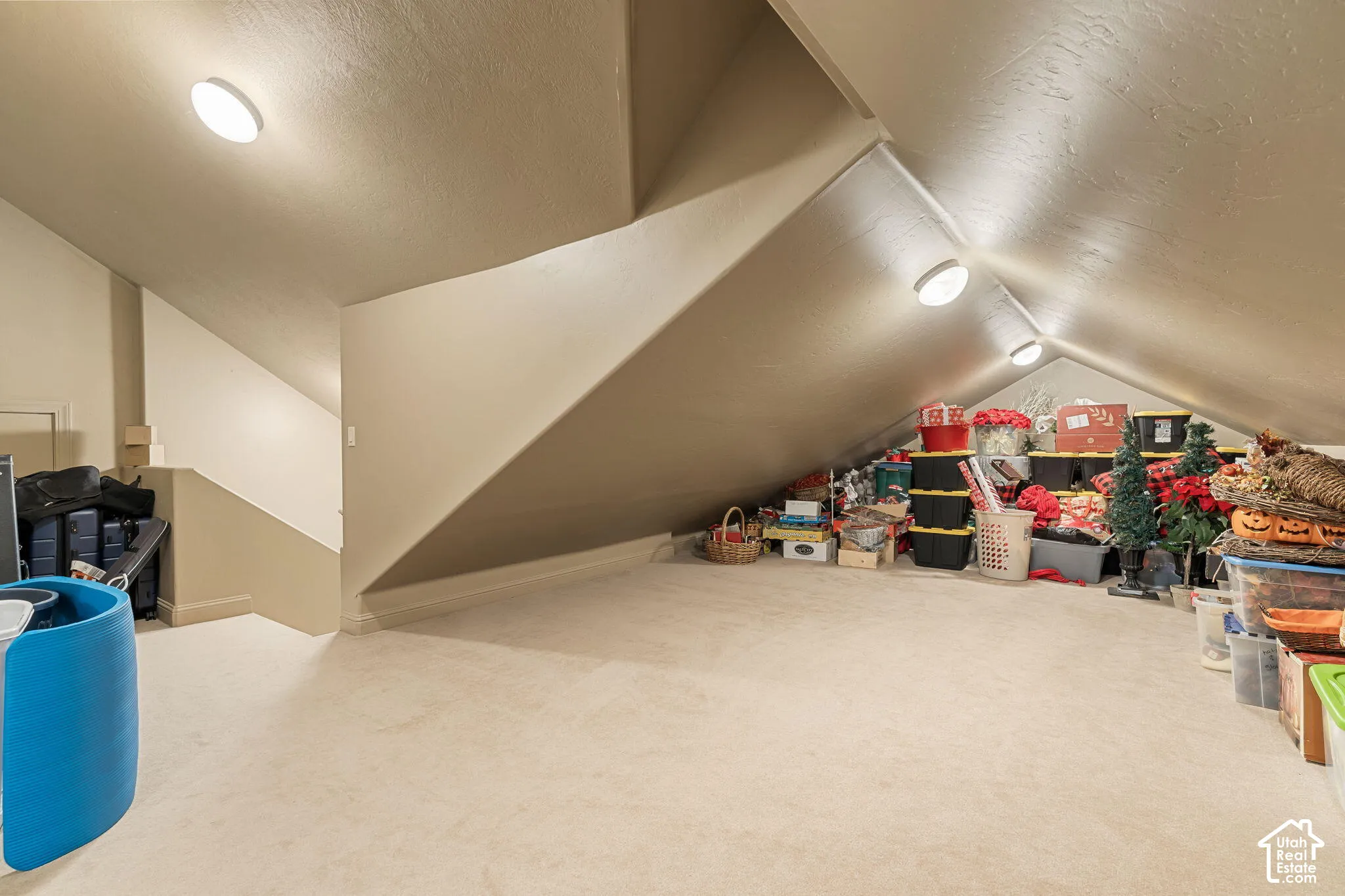 Carpeted attic space with sloped ceilings, recessed lighting, and wall-to-wall carpeting