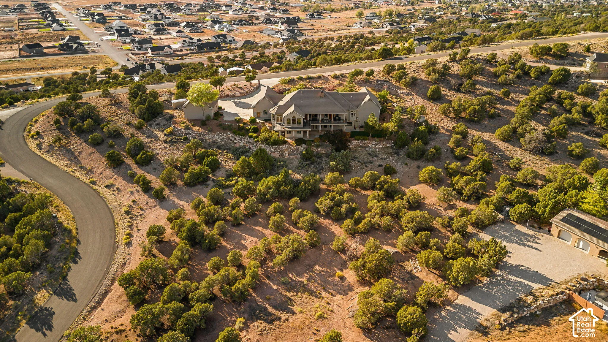 Expansive property featuring a multi-level residence with a covered balcony, an attached garage, and a separate detached garage with solar panels