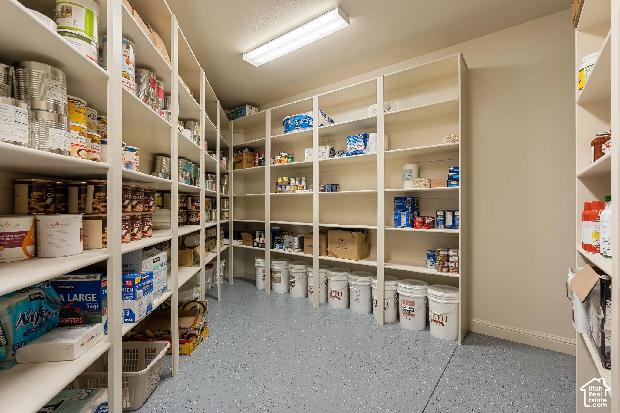 Expansive pantry featuring extensive built-in shelving, durable flooring, and recessed lighting