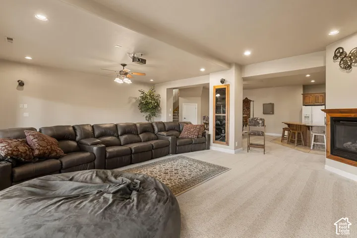 Recessed lighting, ceiling fan, built-in fireplace with wood mantel, built-in bar with wood cabinetry, and carpeted flooring