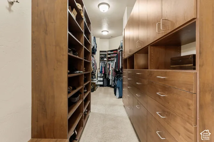 Expansive custom closet featuring extensive wood-finish shelving, built-in drawer storage, and integrated overhead cabinetry