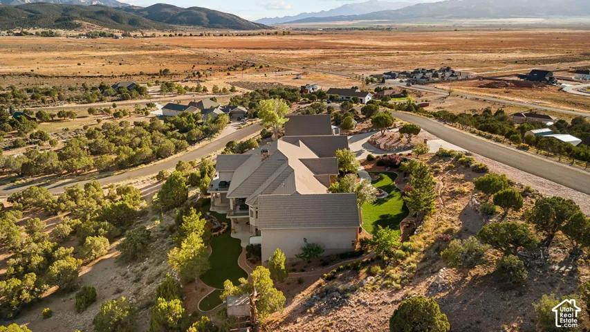 Expansive property featuring a multi-level structure with a gabled roof, terraced landscaping, and a manicured green space