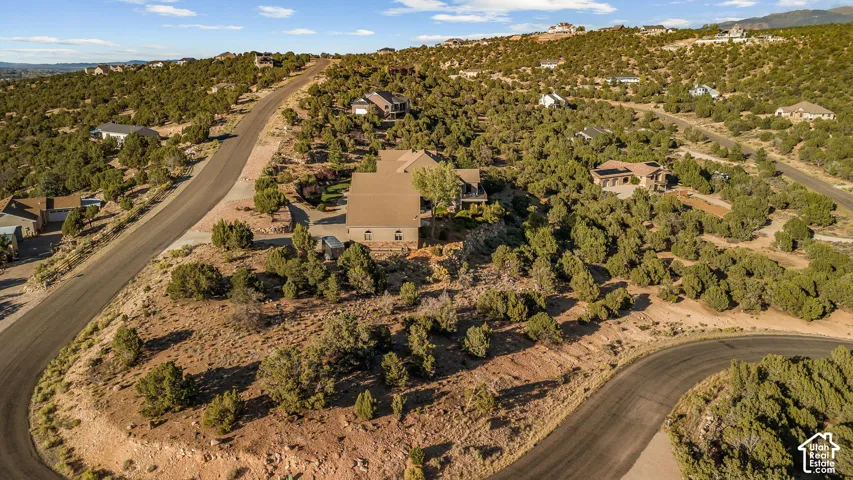Extensive property situated on a winding paved road, surrounded by natural desert landscaping and scattered residences