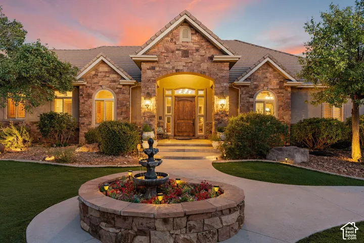 Stone veneer exterior with gabled roof lines, featuring an arched entryway with a solid wood door