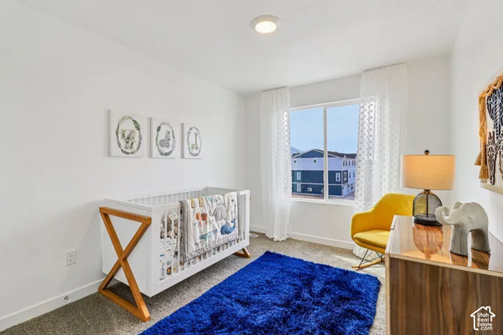 Carpeted flooring, recessed lighting, and a large window with sheer drapery